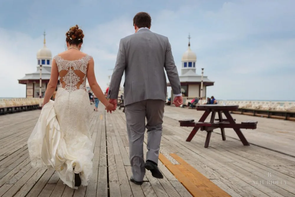 Bride and Groom walk hand in hand on North Pier in Blackpool