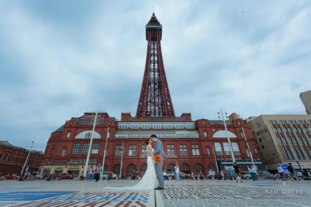 Bride and Groom stand on the Comedy Carpet in front of Blackpool Tower
