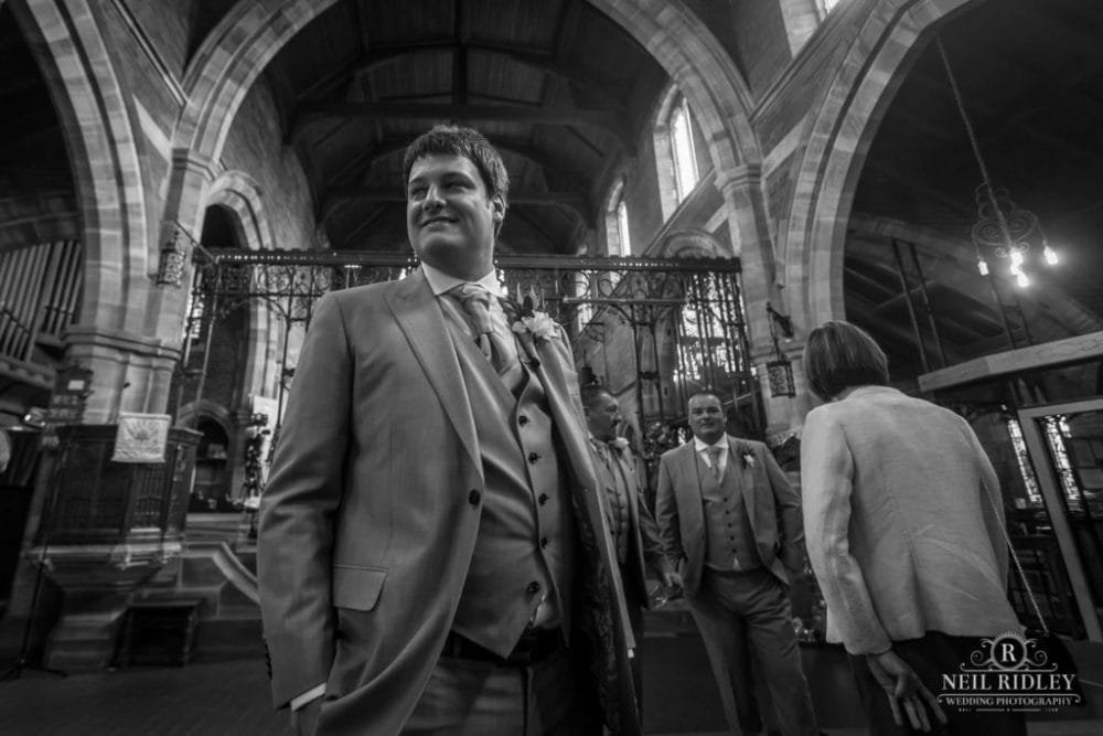 Black and white image of Groom waiting for his for Bride at the church altar at St Thomas Church in St Annes-on-Sea