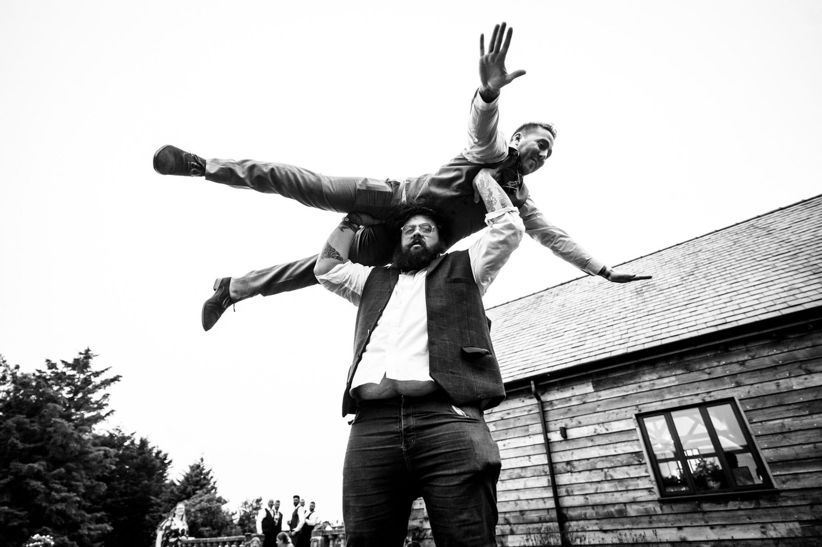 Man raises another man above his head at a Poulton Wedding